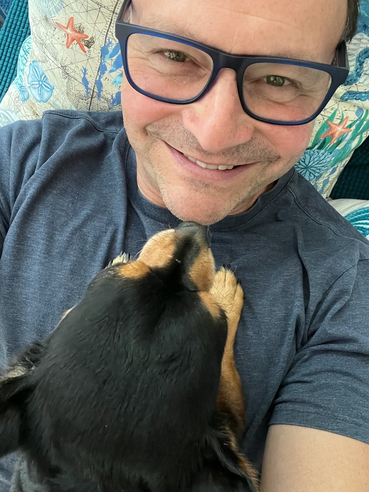 Lou Leyes of Stages Planning Group, smiling and holding his dog